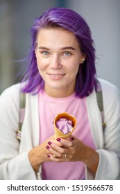 Young Lady With Gray Eyes, Beautiful Purple Hair And Pierced Nose, In White Cardigan And Pink T-short, Holding In Her Hands Violet Ice Cream. Hands With Violet Nails And Ring Weared.