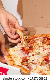 Young Lady Hand Grabbing A Slice Of All Meat Pizza 