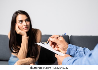 Young Lady Having Depression Sitting On The Couch Opposite To Psychotherapist And Crying.