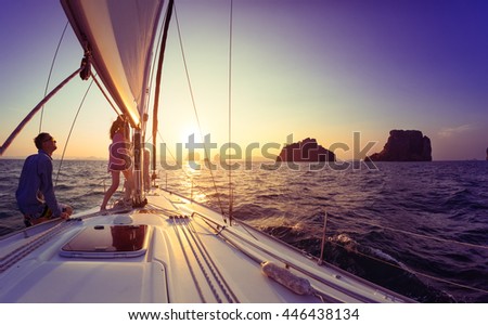 Young lady and man working with sail and rope on the sailing boat