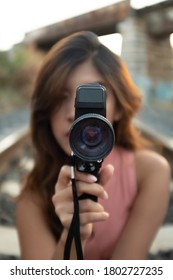 A Young Lady In Pink Holding A Super 8 Film Camera On A Nice Beautiful Day