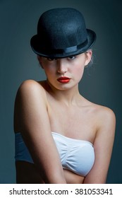 young lady posing in a black bowler hat