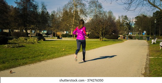 Young Lady Running Ina Central Park During Sunset