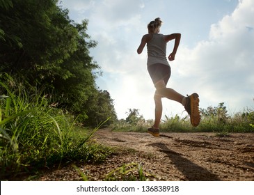 Young lady running on a rural road during sunset - Shutterstock ID 136838918