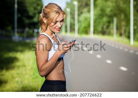 Similar – Woman with earphones listening music in smartphone