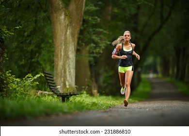 Young lady running. Woman runner running through the spring park road. Workout in a Park. Beautiful fit Girl. Fitness model outdoors. Weight Loss - Powered by Shutterstock