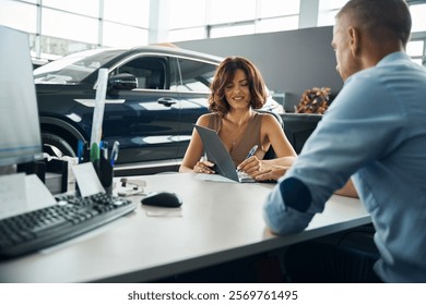Young lady signing documents while buying new car
