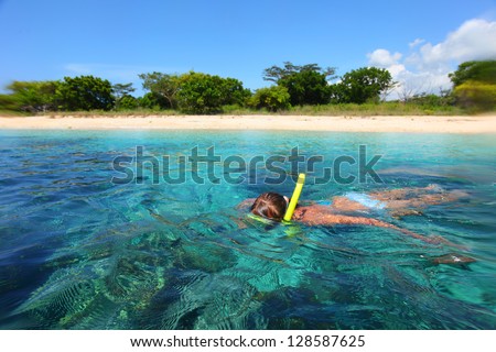 Young lady snorkeling in a tropical sea