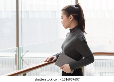 Young lady with tablet computer staring into the distance - Shutterstock ID 1816987607