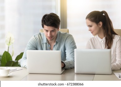 Young Lady Taking Inquisitive Glance, Sneak Peek At Laptop Screen Of Male Colleague, Stealing Private Information From Computer Of Competitor, Nosy Female Coworker Sitting Next To Man Spying On Him