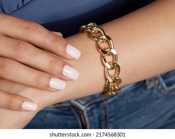 Young Lady With Thick Gold Chain Bracelet On Her Arm