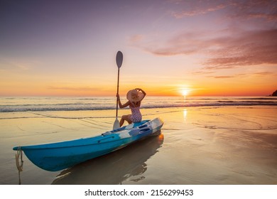 Young lady tourist and canoe on the beach with sunset on the sea at Phuket province, Thailand. - Shutterstock ID 2156299453