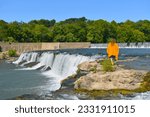 A young lady walks on the rocky outcropping above Grand Falls at Joplin, Missouri, MO, United States, US, USA.  Missouri