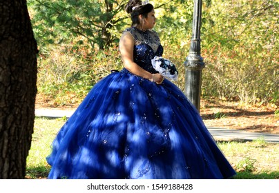 Young Lady Wearing Blue 18th Century Bridesmaid Dress And Silver Tiara And Blue And White Bouquets Pose For Photos In Prospect Park In Brooklyn Ny October 3 2019