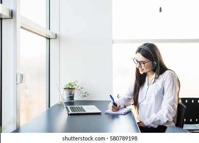 Young Lady Work In Call Center And Make Notice In Book