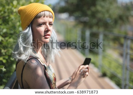 Young lady with a yellow hat using her phone