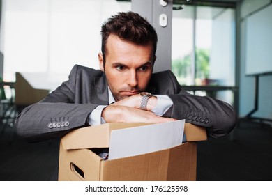 Young Laid Off Manager Sitting Down With A Carton