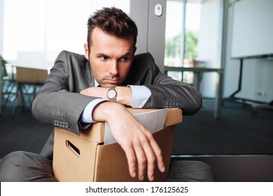 Young Laid Off Manager Sitting Down With A Carton