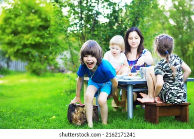 A Young Large Family At A Picnic On A Summer Morning. A Beautiful Mother With Children Is Having Breakfast In The Park.