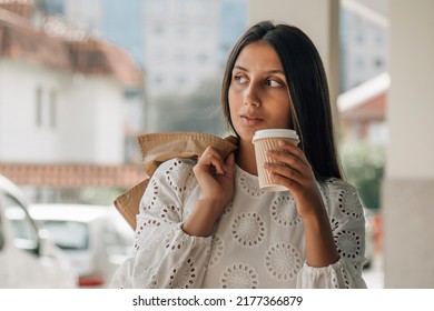 young latin american girl with coffee to go on the street