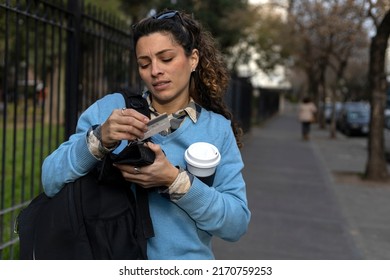 A Young Latin American Student Searches Her Backpack For Her Wallet, Money And Credit Card.