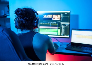 Young Latin American using the computer at night, editing videos and exporting audiovisual pieces. Person using a computer to create content from home. video editor, pc gamer - Shutterstock ID 2157371849