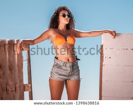 Similar – Brunette surfer woman with top and bikini holding surfboard