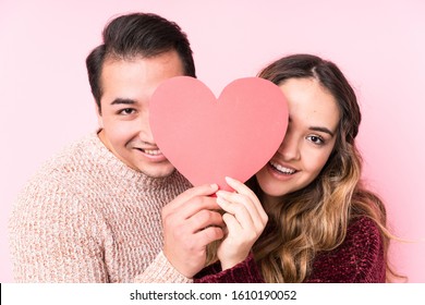 Young Latin Couple Holding A Heart Sticker