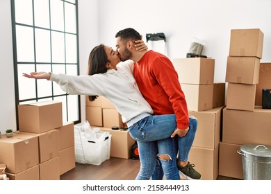 Young Latin Couple Kissing And Dancing At New Home