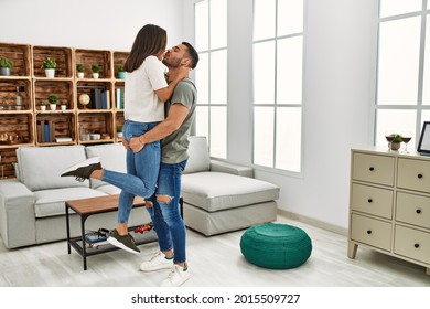 Young Latin Couple Kissing And Hugging At Home.