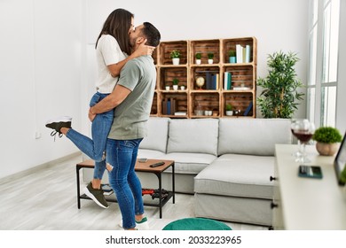 Young Latin Couple Kissing And Hugging At Home.