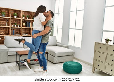 Young Latin Couple Kissing And Hugging At Home.