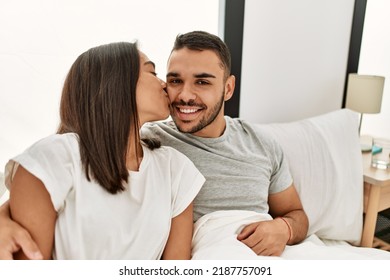 Young Latin Couple Kissing And Hugging On The Bed At Home.