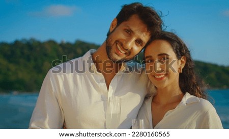 Young Latin couple looks towards the camera with beaming smiles, their affection for each other radiating from their eyes and warming the hearts of all who see them. Slow motion shot.