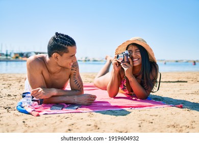 Young Latin Couple Make Photo Using Vintage Camera At The Beach.