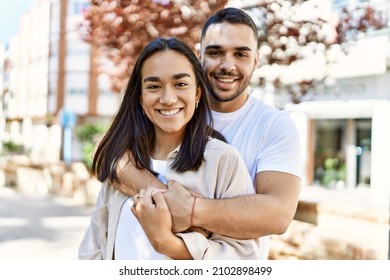 Young latin couple smiling happy and hugging at the city. - Shutterstock ID 2102898499
