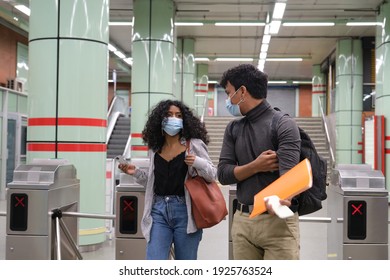 Young Latin Couple Wearing Protective Face Mask Walking Through Subway Turnstile At The Train Or Metro Station. New Normal At Public Transport.