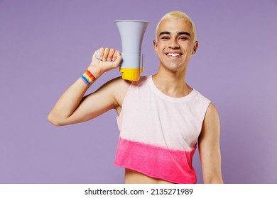 Young latin gay man with make up wearing bright pink top hold scream in megaphone announces discounts sale Hurry up isolated on plain pastel purple background. People lifestyle fashion lgbtq concept