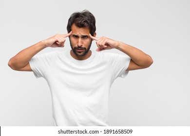 young latin handsome man with a concentrated look, wondering with a doubtful expression, looking up and to the side - Shutterstock ID 1891658509