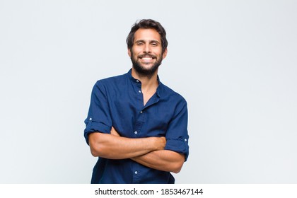 young latin handsome man looking like a happy, proud and satisfied achiever smiling with arms crossed