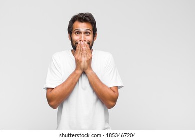 Young Latin Handsome Man Looking Happy And Excited, Shocked With An Unexpected Surprise With Both Hands Open Next To Face