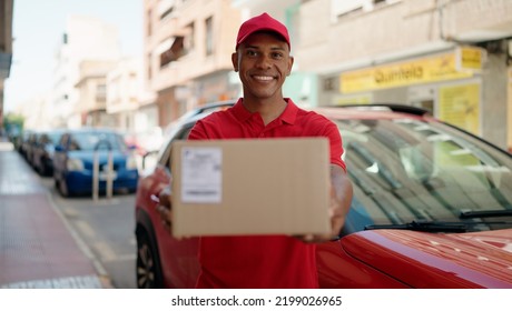 Young Latin Man Delivery Worker Holding Package At Street