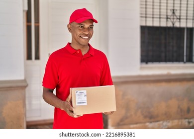 Young Latin Man Delivery Worker Holding Package At Street