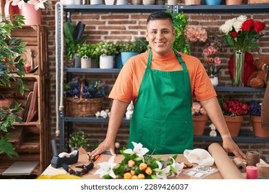 Young latin man florist smiling confident standing at flower shop - Powered by Shutterstock