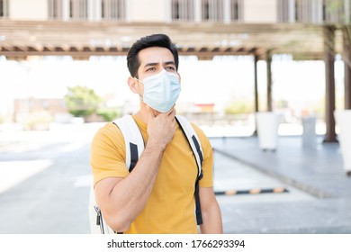 Young Latin Man Suffering From Throat Pain While Wearing Face Mask In City During COVID19 Crisis