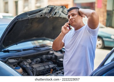 Young latin man talking on smartphone with insurance for car breakdown at street - Shutterstock ID 2222223057