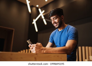 Young latin man using cell phone. Texting on cafe. - Powered by Shutterstock