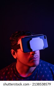 Young Latin Man Using Virtual Reality VR Headset 3D Glasses. Studio Dark Backdrop. Low Key. Copy Space