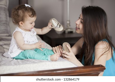 Young Latin Mom Getting Her Baby Girl Dressed