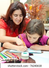 Young Latin Mother Helping Her Daughter With Her Art Project